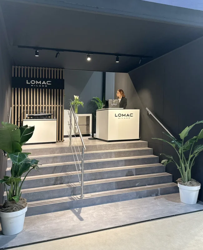 Persona di fronte al desk sulle scale di benvenuto aall'ingresso allo stand Lomac alla fiera Boot di Dusseldorf.